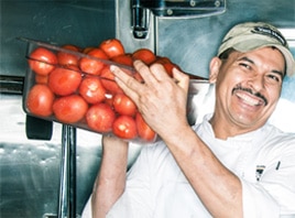 What is Second Harvest? A Yard House chef holds a bin of fresh tomatoes